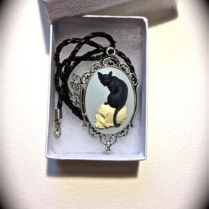 Cat sitting on skull cameo necklace