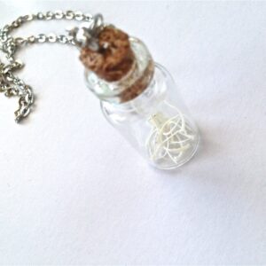 Glass vial of snake ribs bones necklace